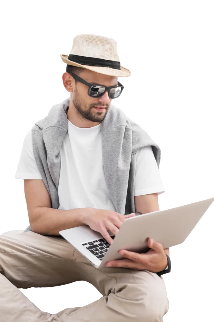 Man wearing hat and sunglasses using laptop, representing social media optimization services with improved media presence and increased lead generation